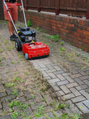 Person using a Westermann WKB330 Weed Ripper to remove weeds from a block paving driveway