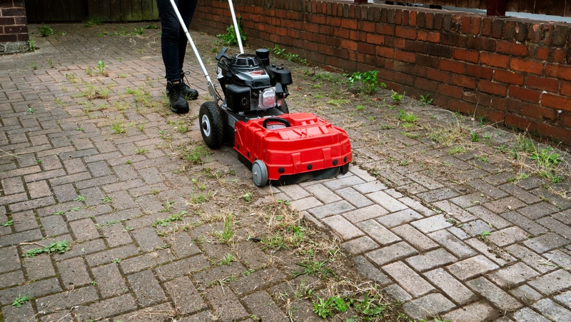 Person using a Westermann WKB430 Weed Ripper to clean weeds from block paving