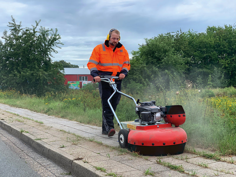 Person using a Westermann WKB660 Weed Ripper to clear weeds from a pavement