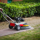 Person using a Westermann WR870 Moss Brush to remove moss from a block paving path