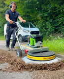 Person using a Westermann Moss Brush to sweep leaves and debris