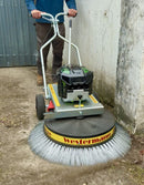 Person using a Westermann Moss Brush on concrete