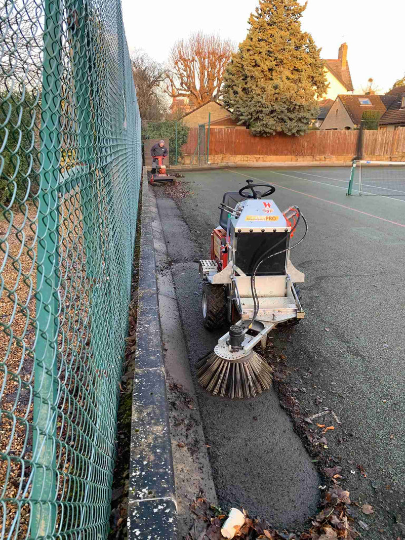 Wkb550 brush head clearing moss from a tarmac tennis court