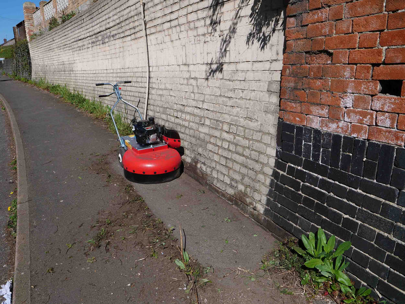 Weeds bring removed from the base of a wall using the Westerman WKB660 weedripper