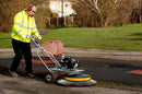 Weed and moss removal from the edge of a rubber children's play area, using the Westermann Moss Brush