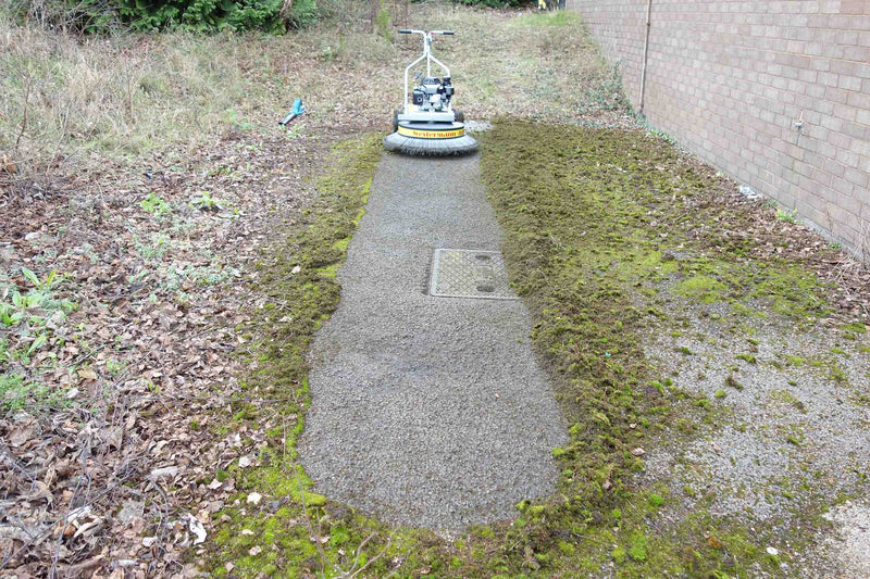 Thick moss being removed from tarmac using the Westermann Moss Brush